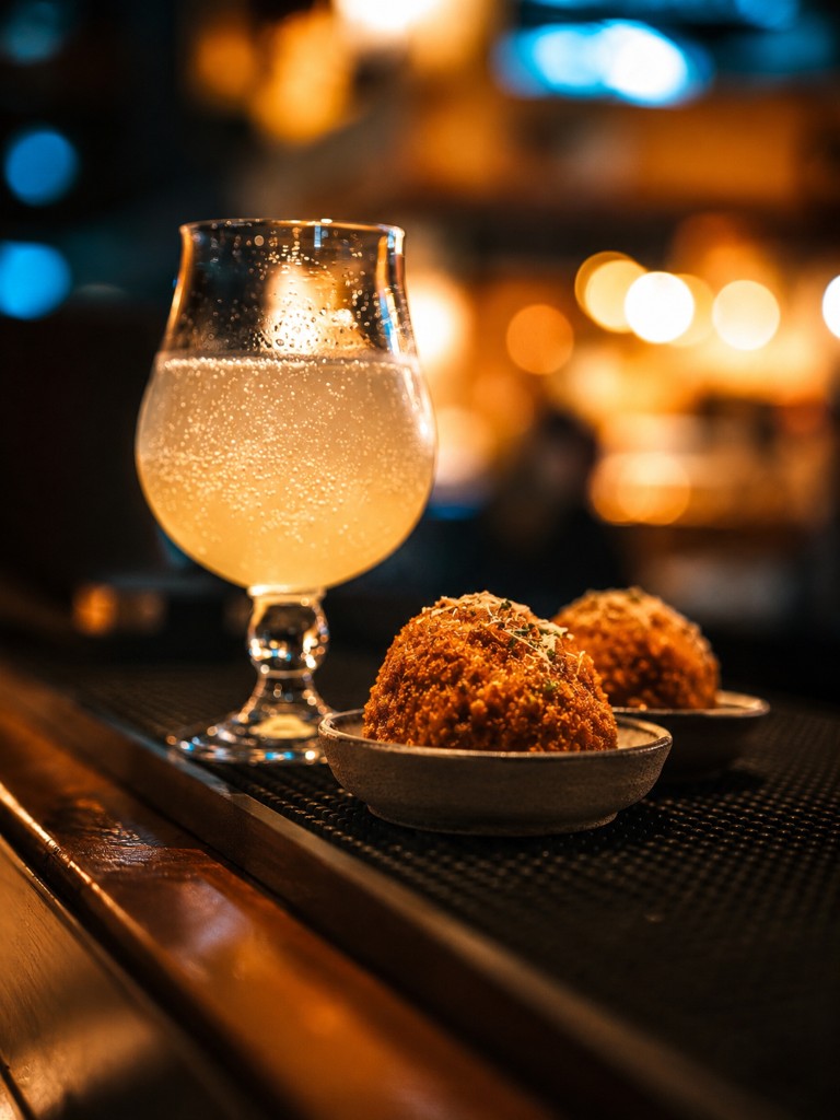 Arancini served with a drink at the bar