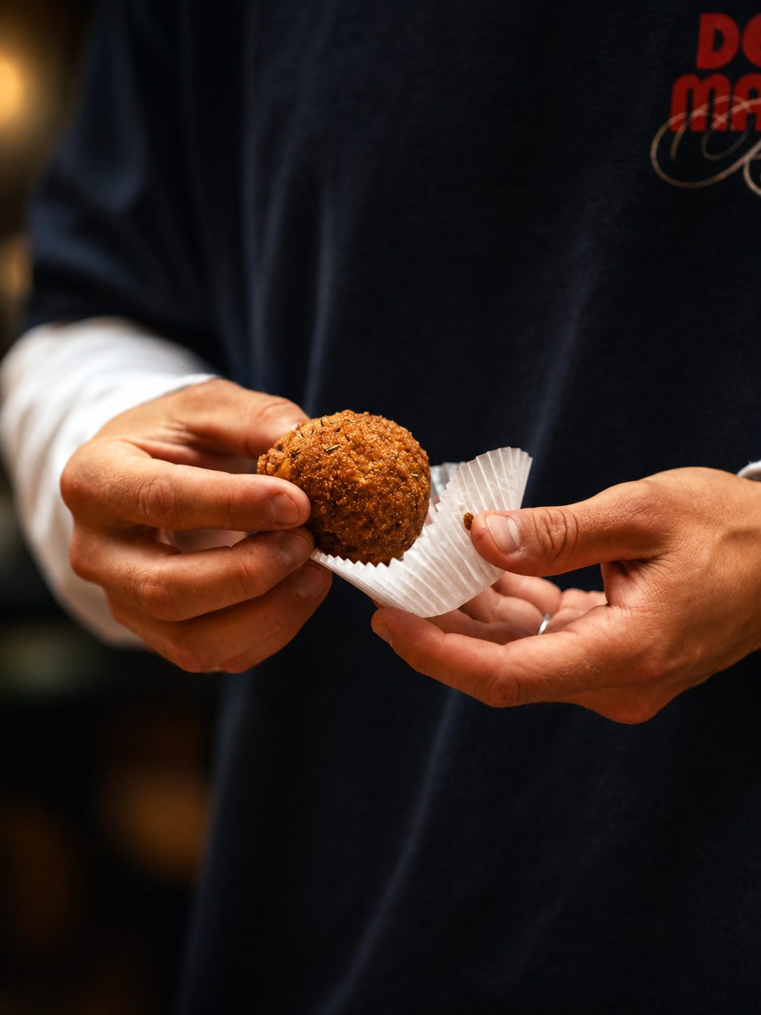 Arancini holdt i hendene, klar til å spises